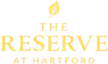 Logo for The Reserve at Hartford: gold text with a leaf above.