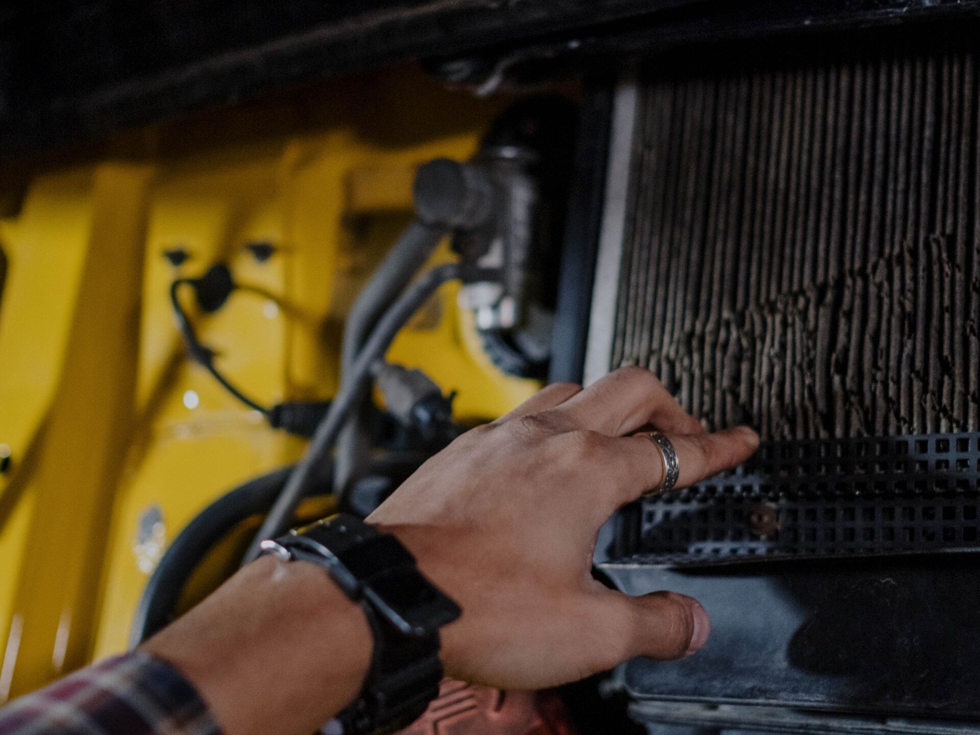 a person is working on a radiator in a car .