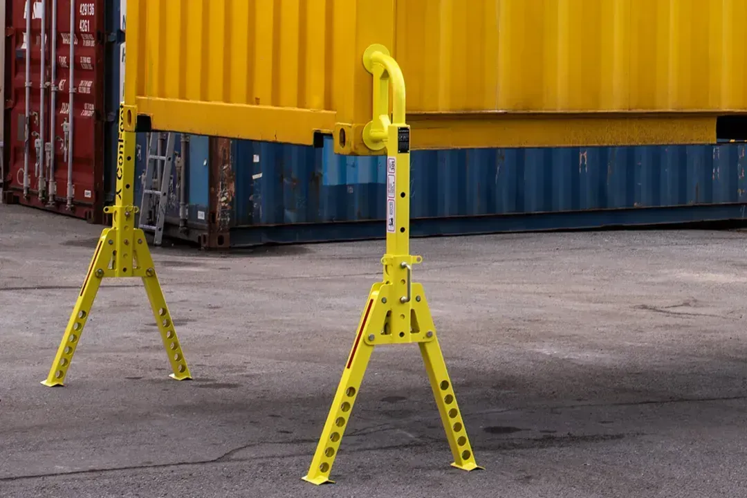 Contenedor de carga amarillo sobre soportes en un patio de carga