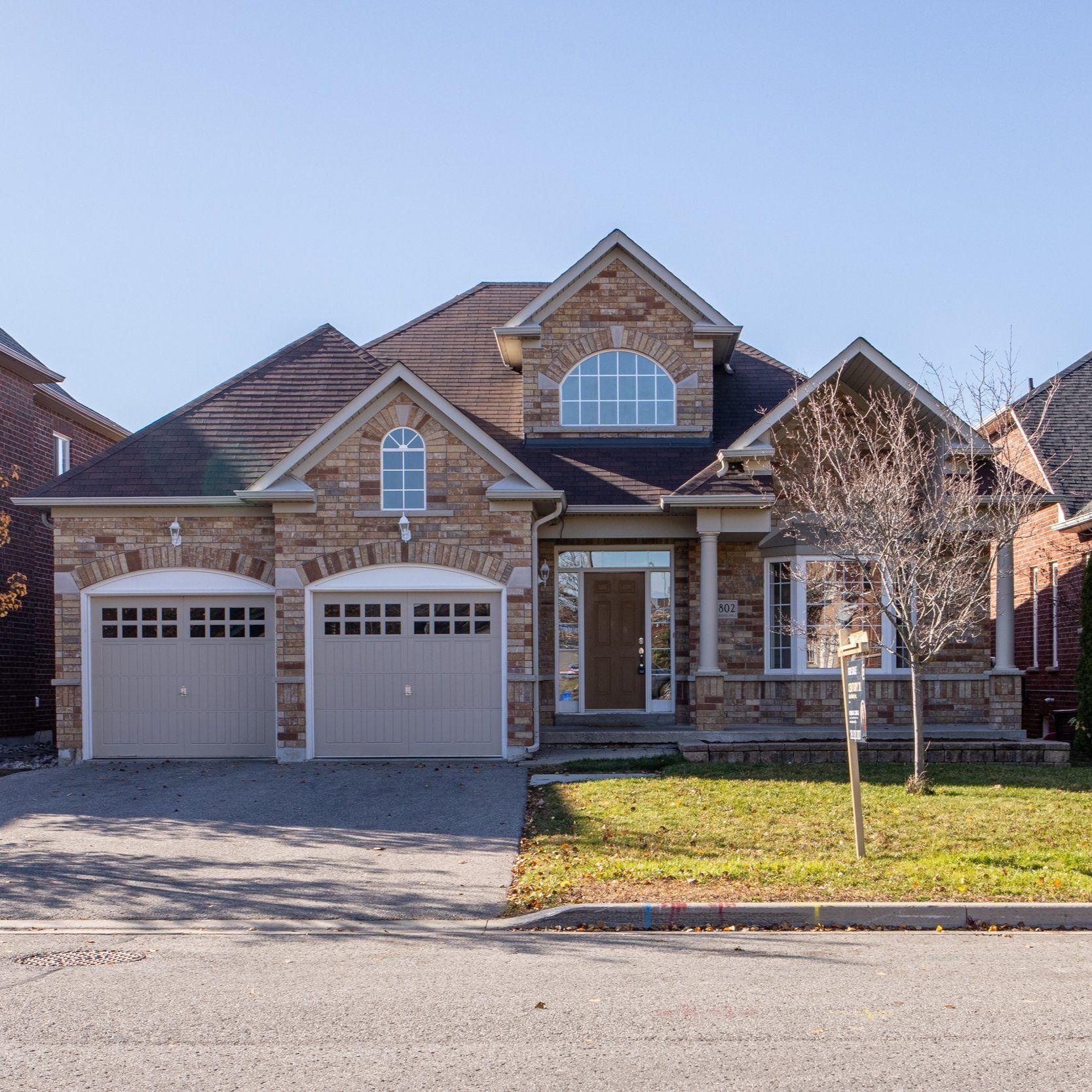 A large brick house with two garage doors is for sale
