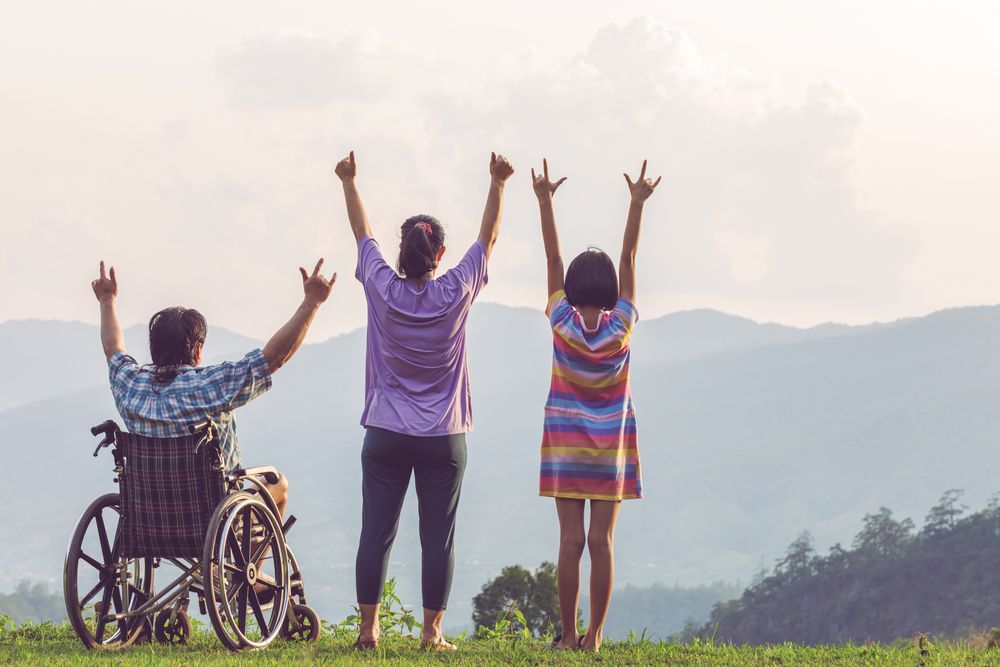 A Man in a Wheelchair is Standing Next to a Woman — Better Access Support Services In Stanthorpe, QLD