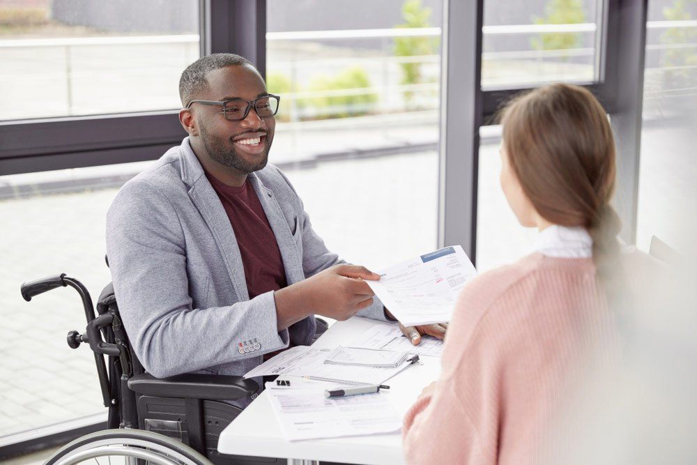 Man Sharing Paperwork — Better Access Support Services In Wyreema, QLD