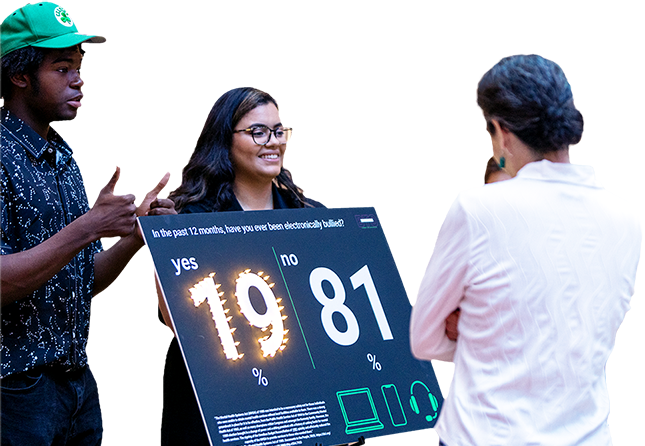 Three people discuss a large digital scoreboard showing 19 and 81 on a white background.
