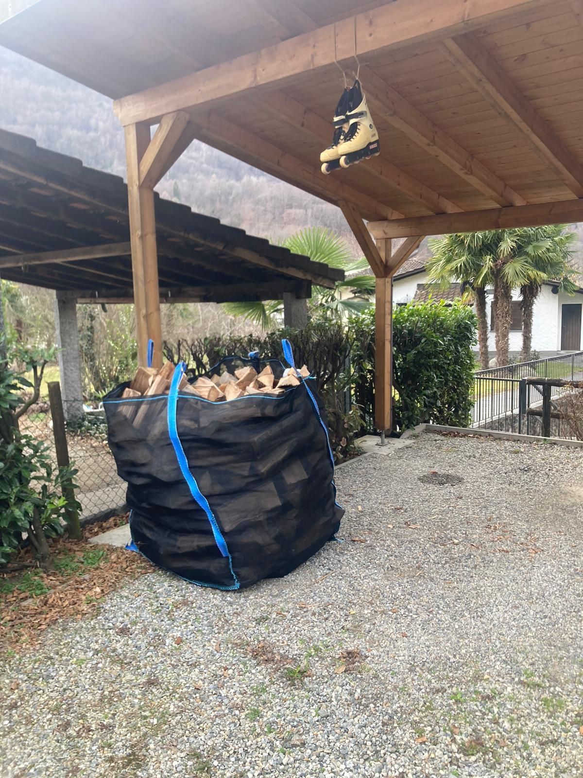 Un sacco di legna è seduto sotto un tetto di legno.