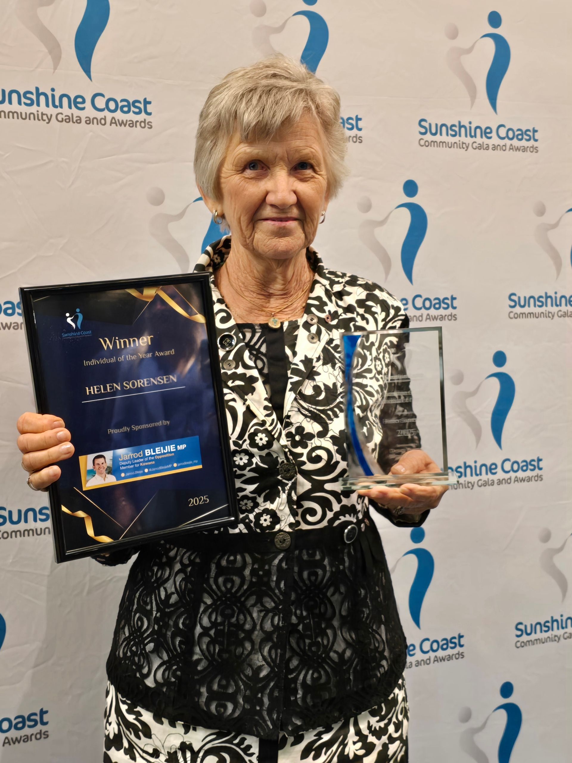Woman holding a framed award and trophy, smiling in front of a banner with a logo. — Equine Alliance in Palmwoods, QLD