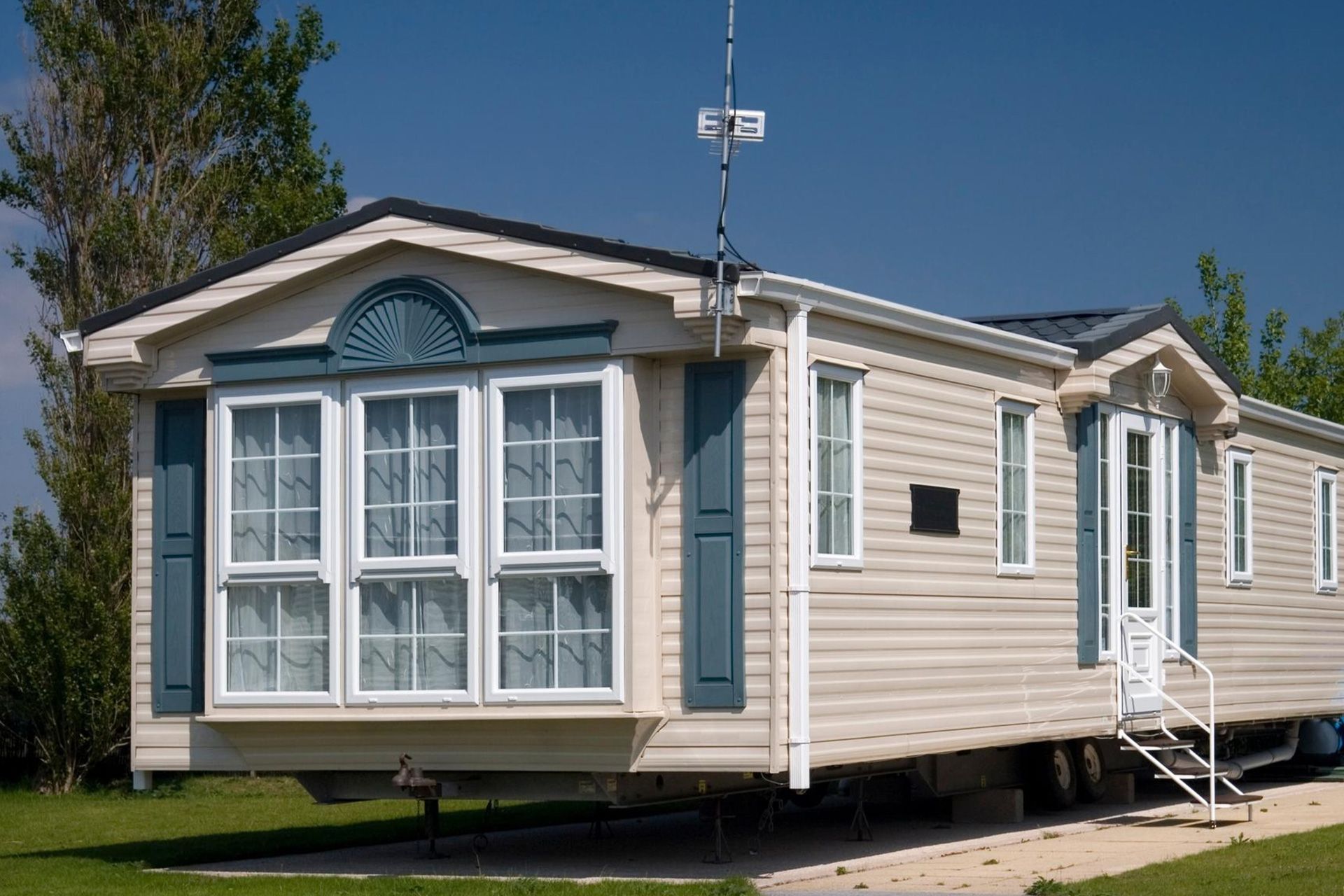 An inspector checking the foundation and exterior of a manufactured home during a Kentucky home insp
