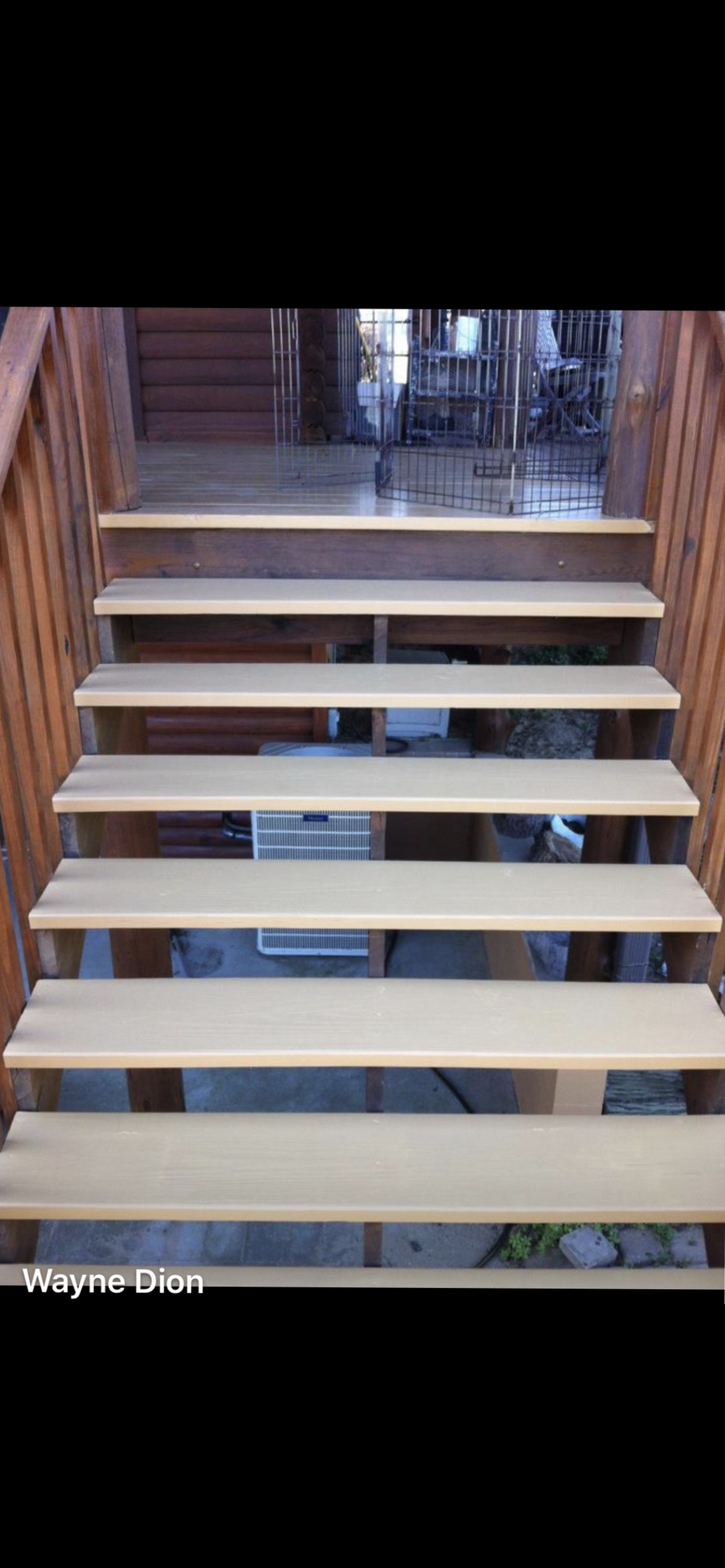 Wooden staircase with brown rails, light-colored steps, leading upwards.