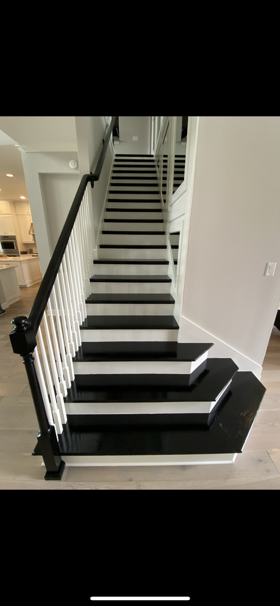 Black and white staircase with white railings and black banister. Interior view of a home.