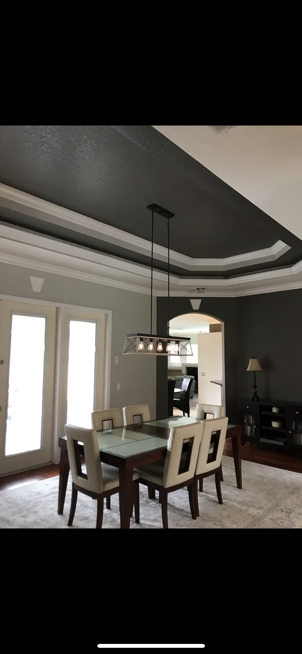 Dining room with dark gray ceiling, white trim, dining table, and chairs.
