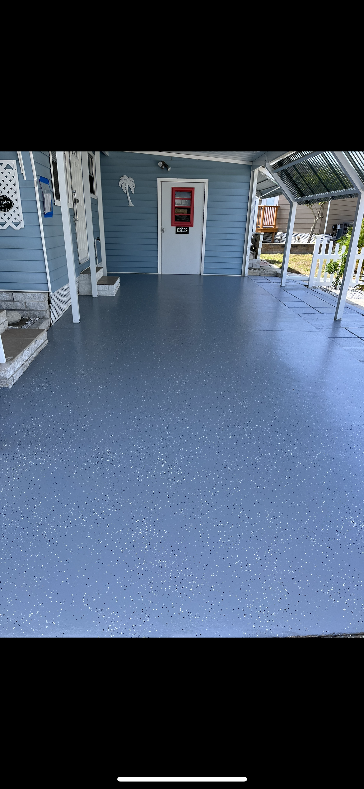 Blue speckled epoxy-coated porch floor with a blue house and white door in the background.