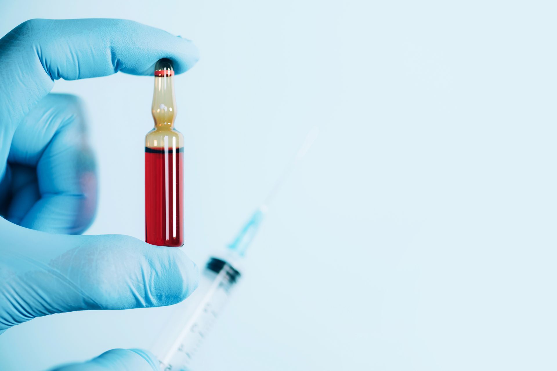 person holding vial and syringe