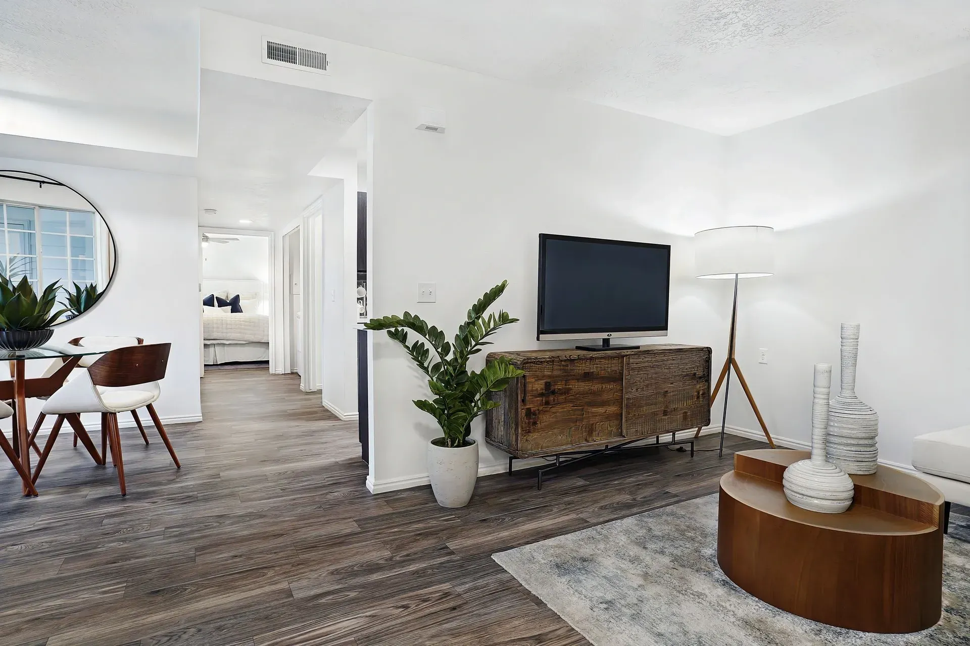 Living room with dining area, TV, and entryway to bedroom