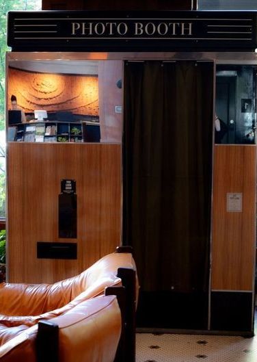 a photo booth is sitting in a hallway next to a window .