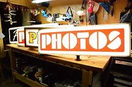 a row of photos signs are sitting on a wooden table .