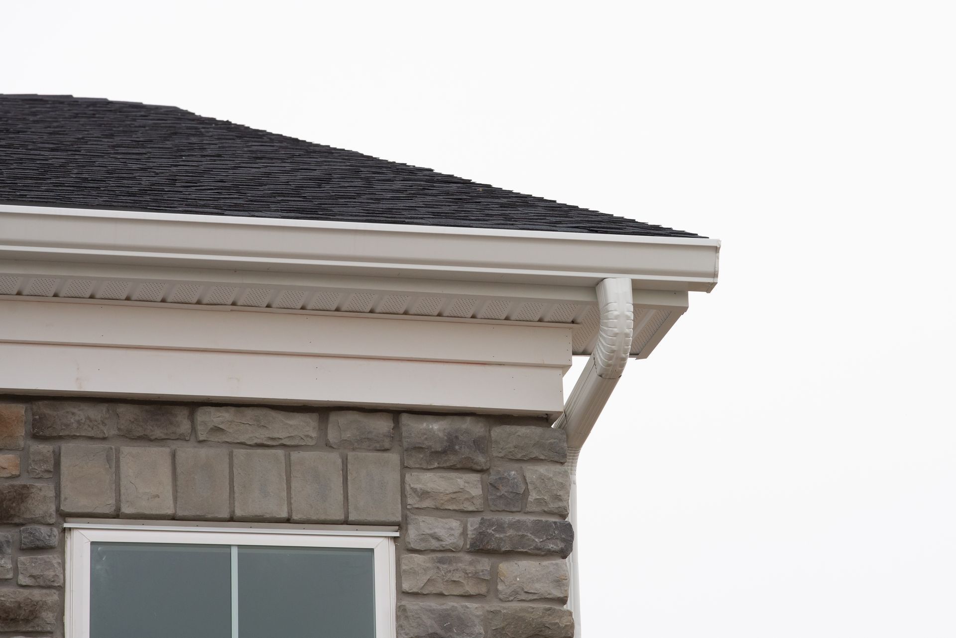 A house with a black roof and a white gutter.