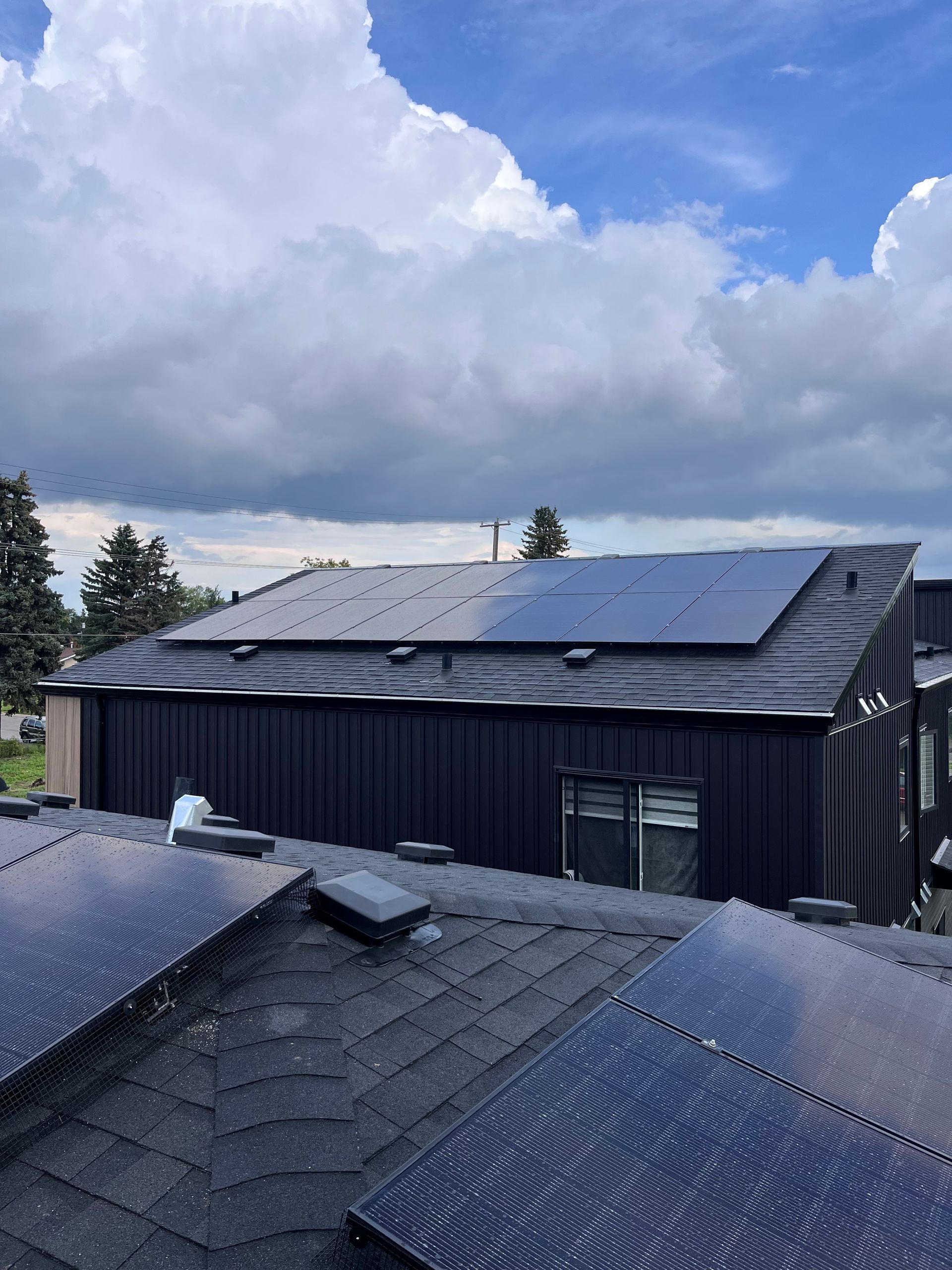 Solar panels on commercial roof with a field and mountains in the background.