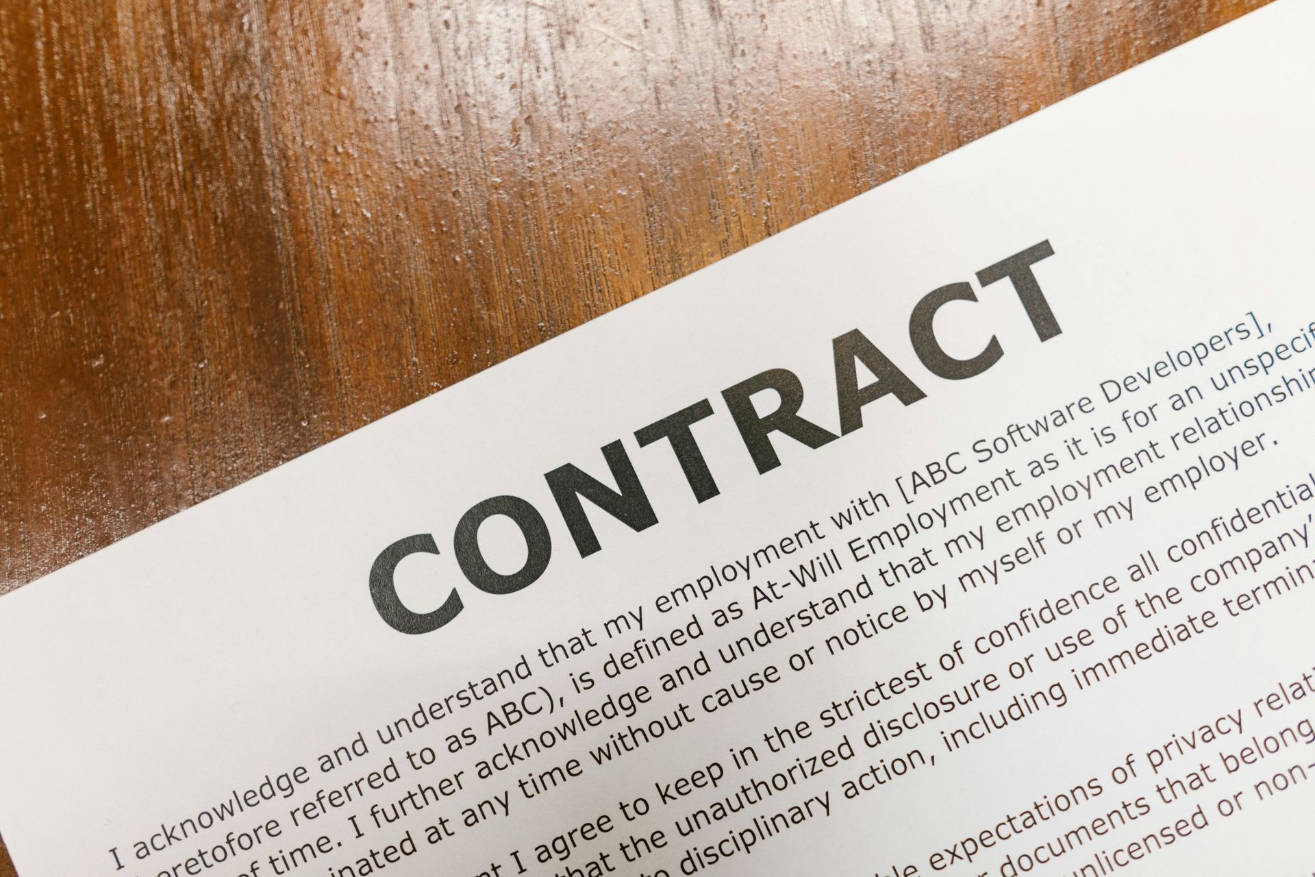 Contract document on a wooden surface, with the title