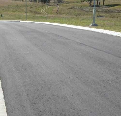 A Newly Paved road with a Grassy hill in the Background — Roll Formed Driveways in Yandina, QLD