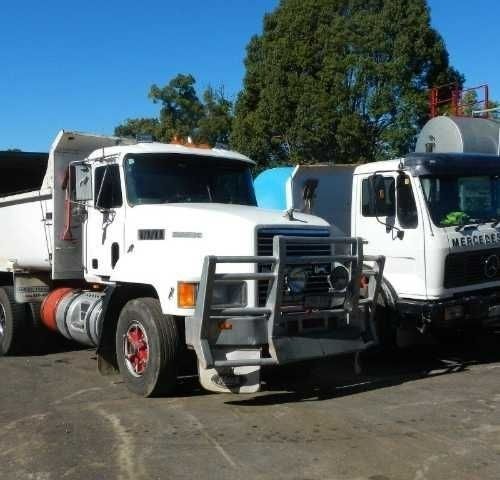 Two Dump Trucks Are Parked Next to Each Other in A Parking Lot — Roll Formed Driveways in Yandina, QLD