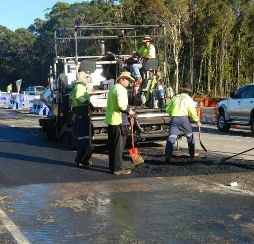 A Group of Construction Workers Are Working on A Road — Roll Formed Driveways in Yandina, QLD