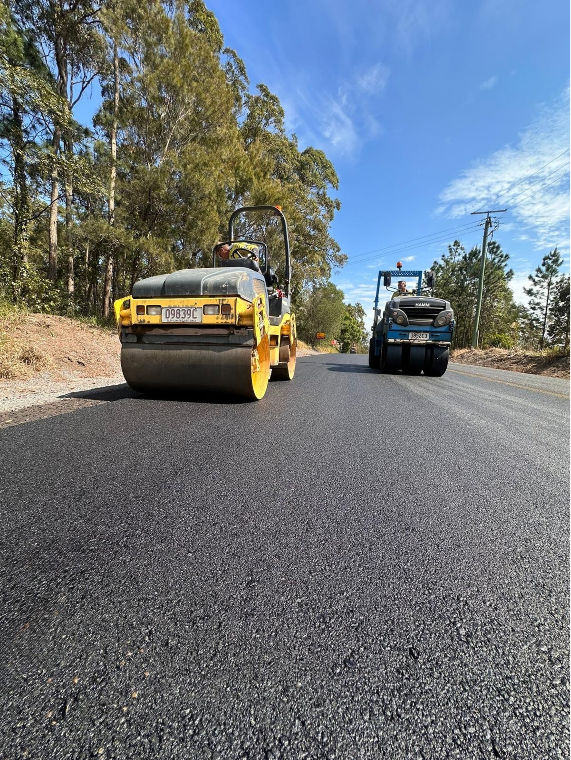 Two Rollers Are Sitting On The Side Of A Road — Roll Formed Driveways in Yandina, QLD