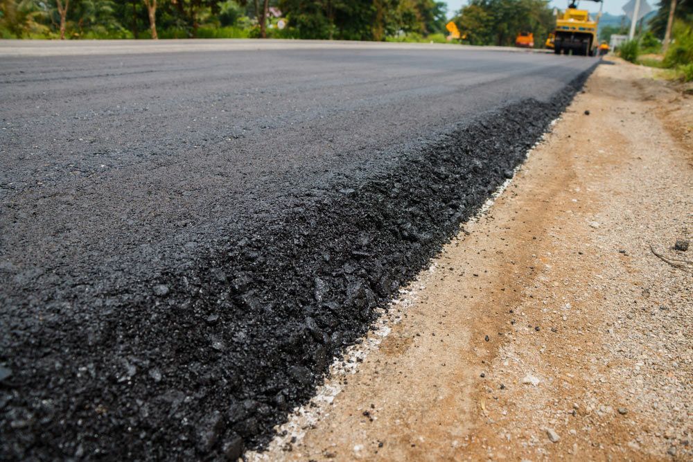 A driveway constructed with a thick layer of asphalt.