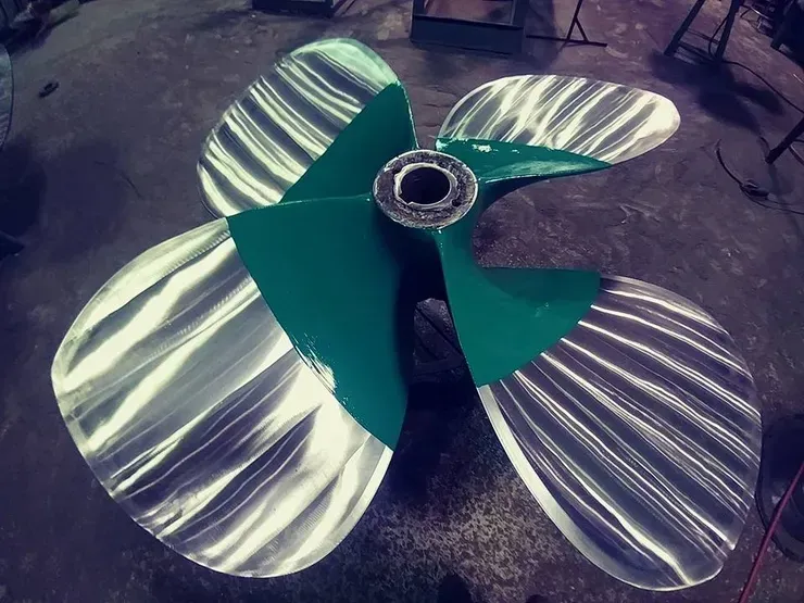 A green and silver propeller with a hole in the middle