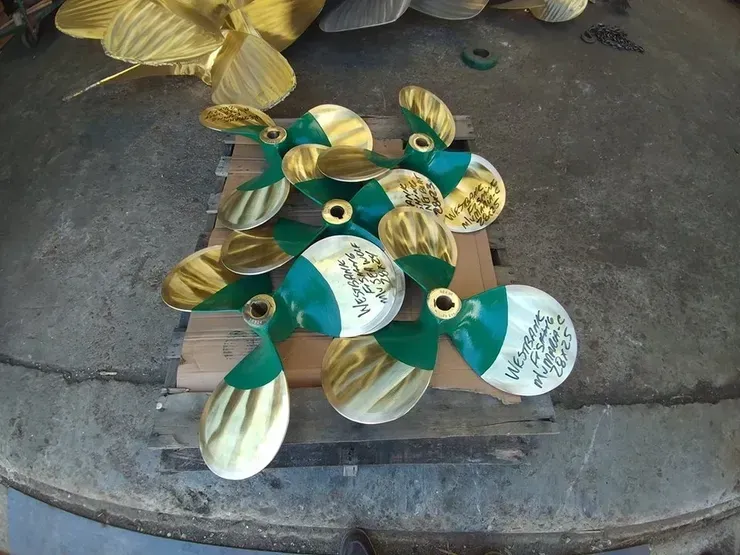 A bunch of propellers are sitting on a wooden pallet