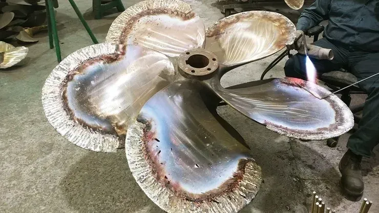 A person is welding a metal object in the shape of a flower.
