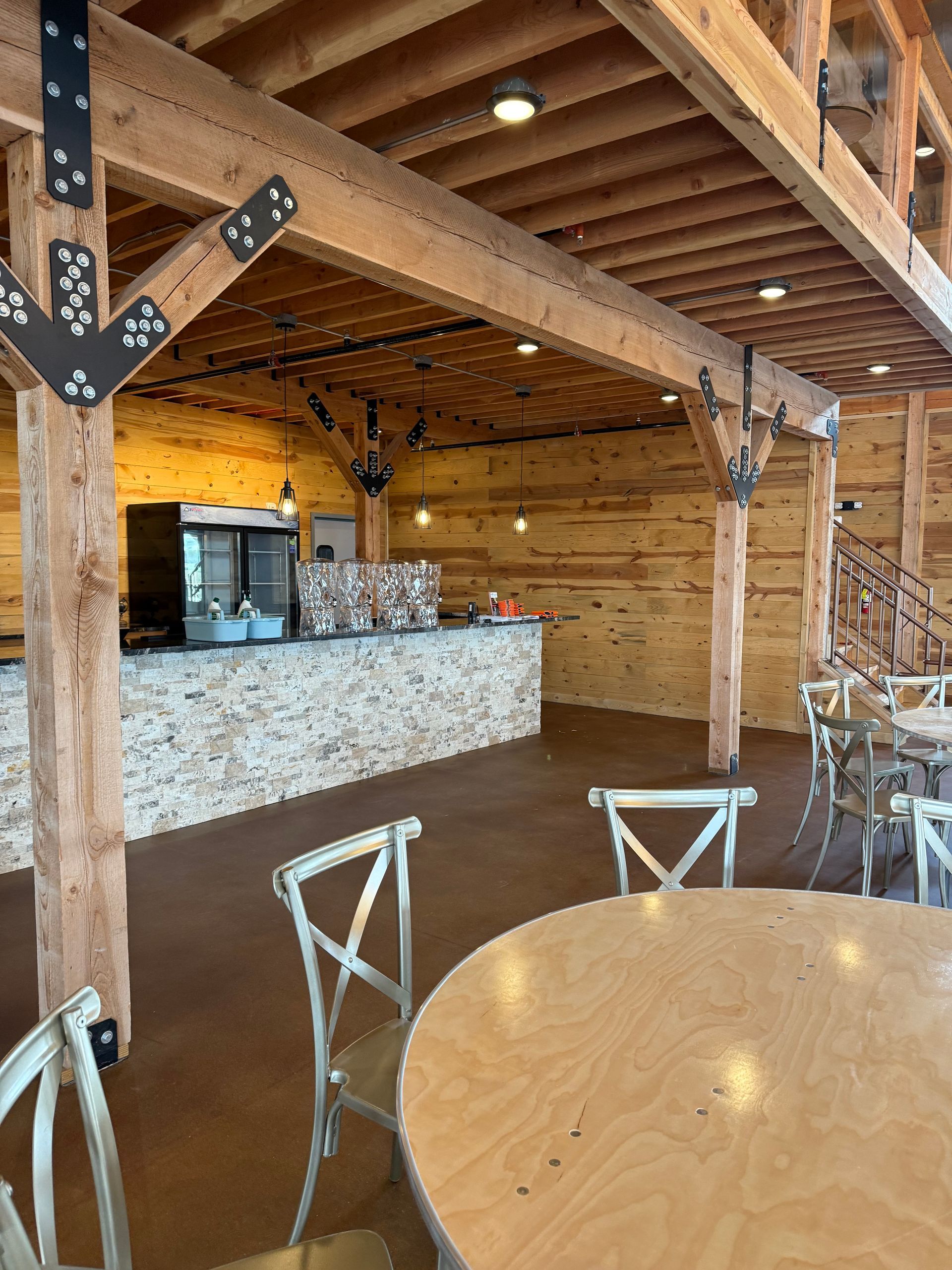 Rustic café interior with wooden beams, stone counter, and round table in the foreground