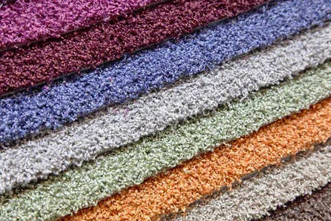 Stacked textured fabric swatches in purple, blue, gray, green, orange, and tan diagonals