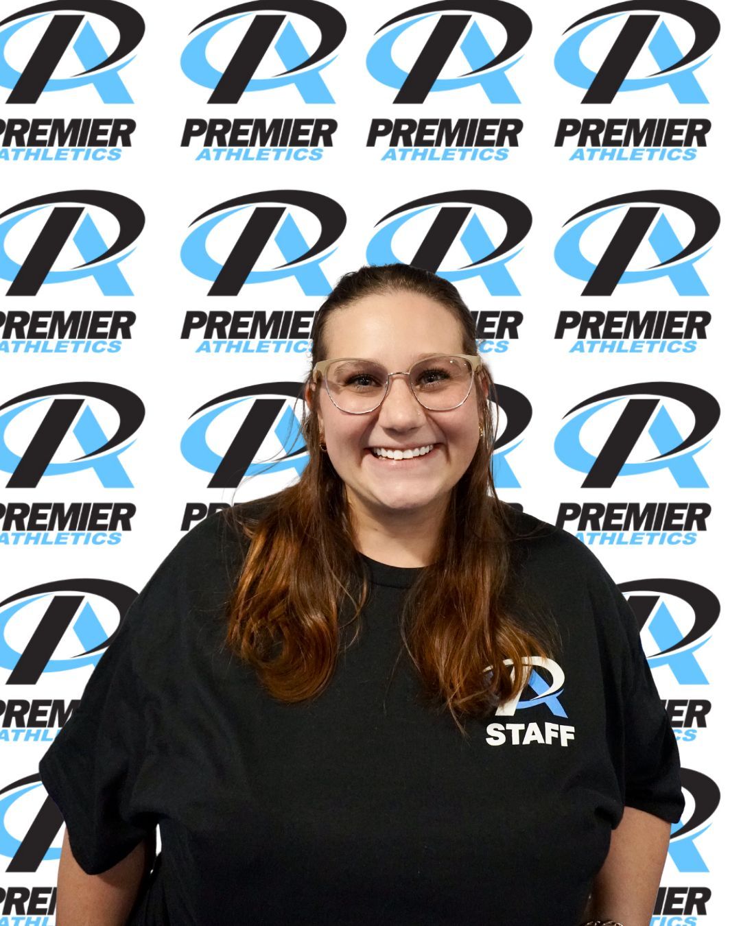 A woman is smiling in front of a blue background