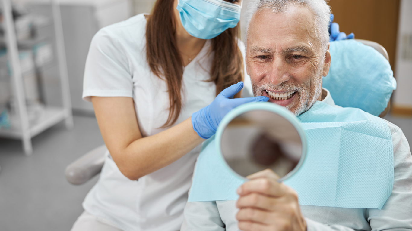 Dentist and patient in office: dentist showing patient his teeth with a mirror.