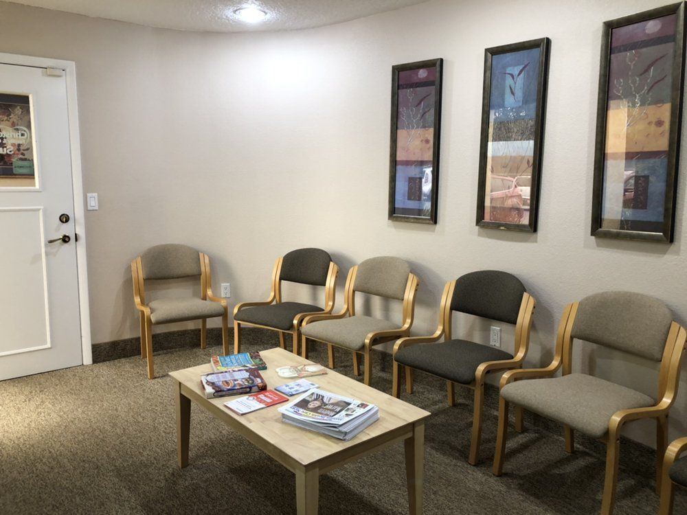 Waiting room with chairs, a table with brochures, and artwork on the wall.