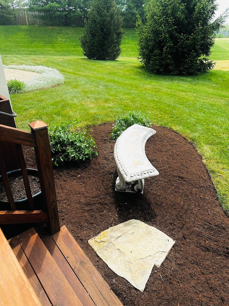 A white bench is sitting in the middle of a lush green yard.