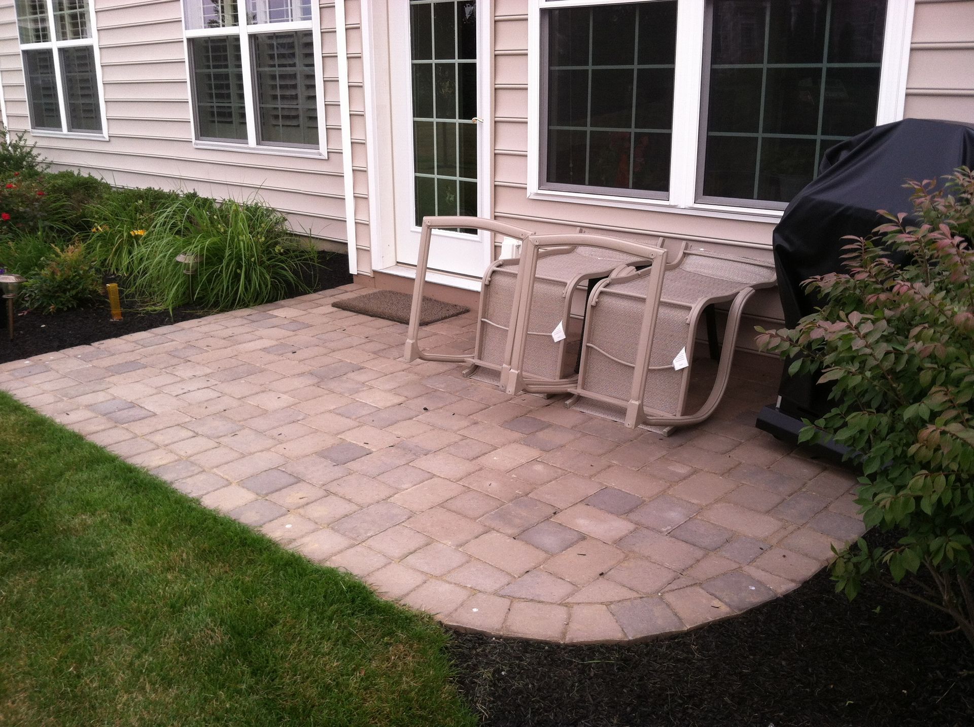 A patio with a table and chairs in front of a house