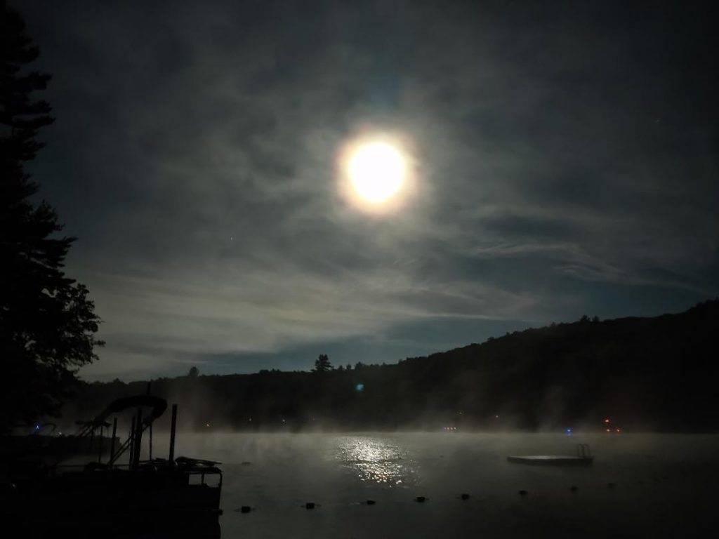 A full moon shines over a lake at night