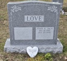 A gravestone with a heart on it in a cemetery.