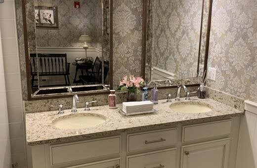 A bathroom with two sinks and a large mirror.