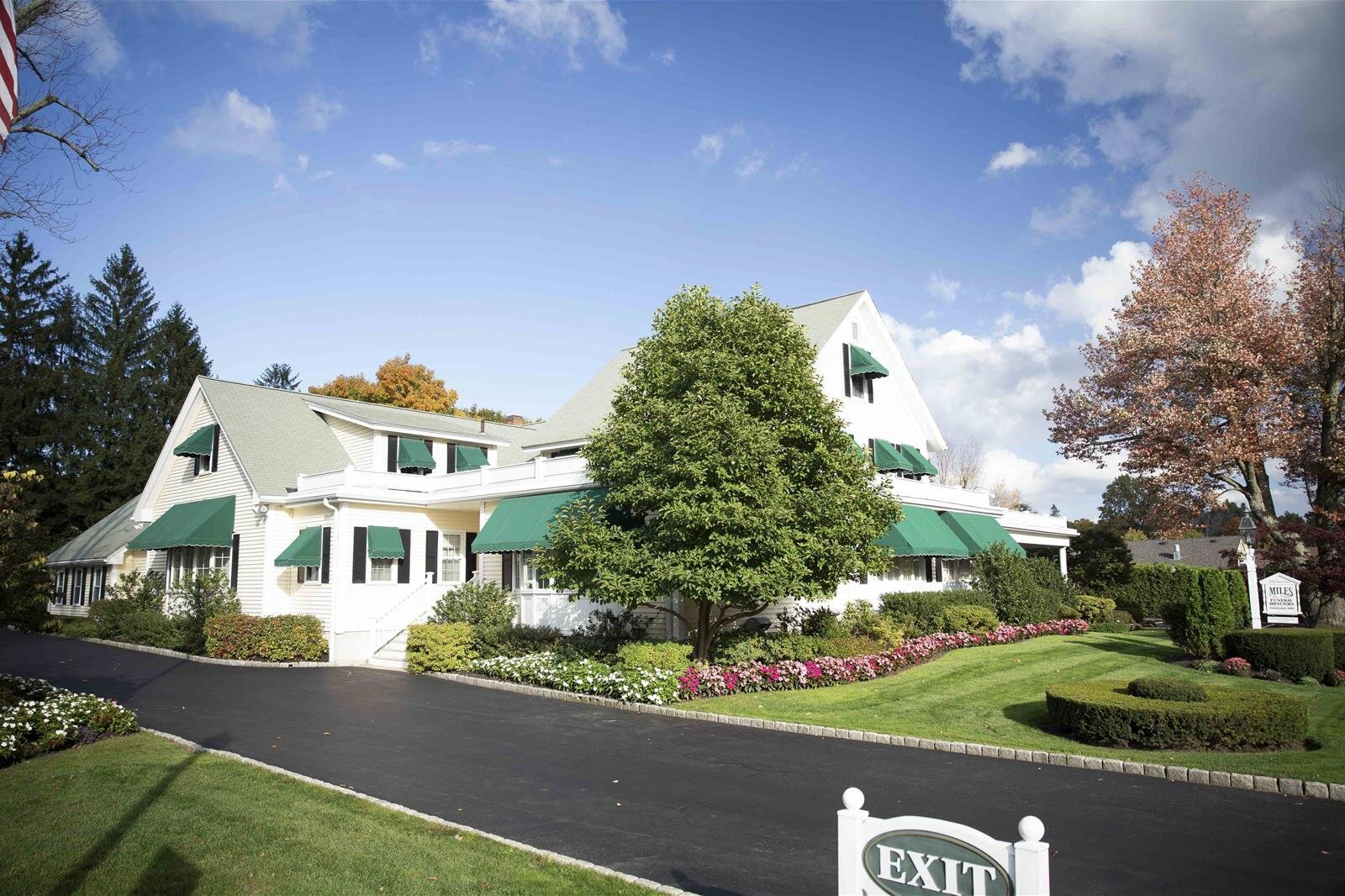 A white house with green awnings and a sign that says exit
