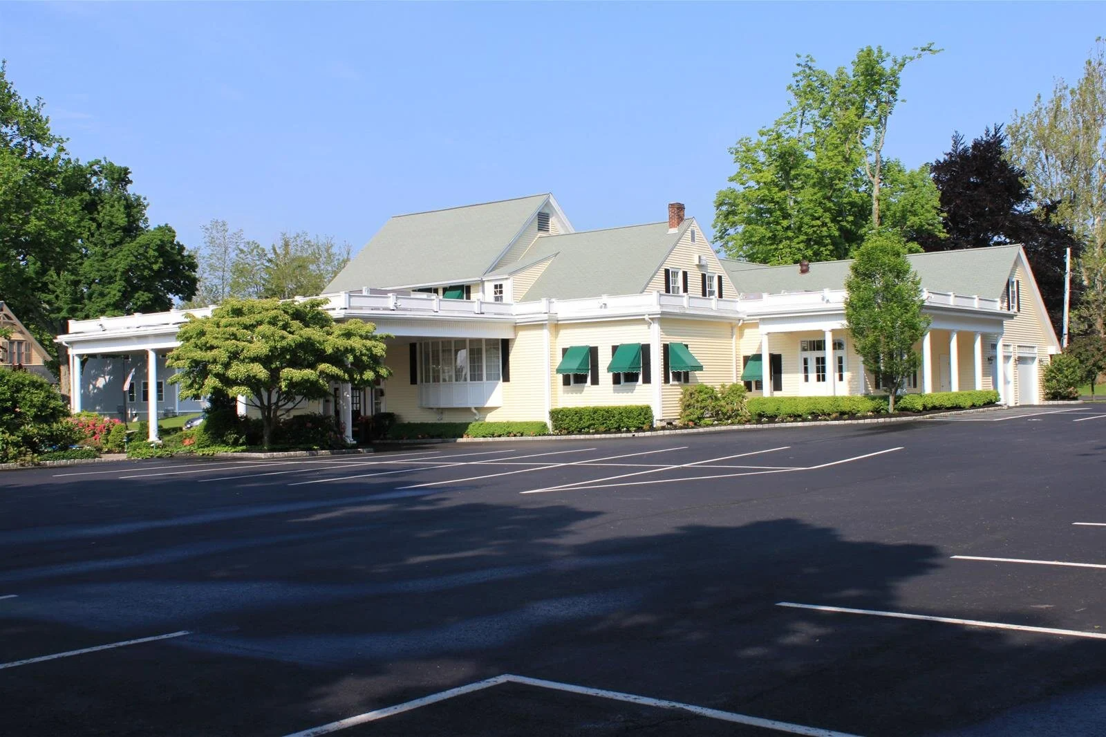 A large house with a parking lot in front of it