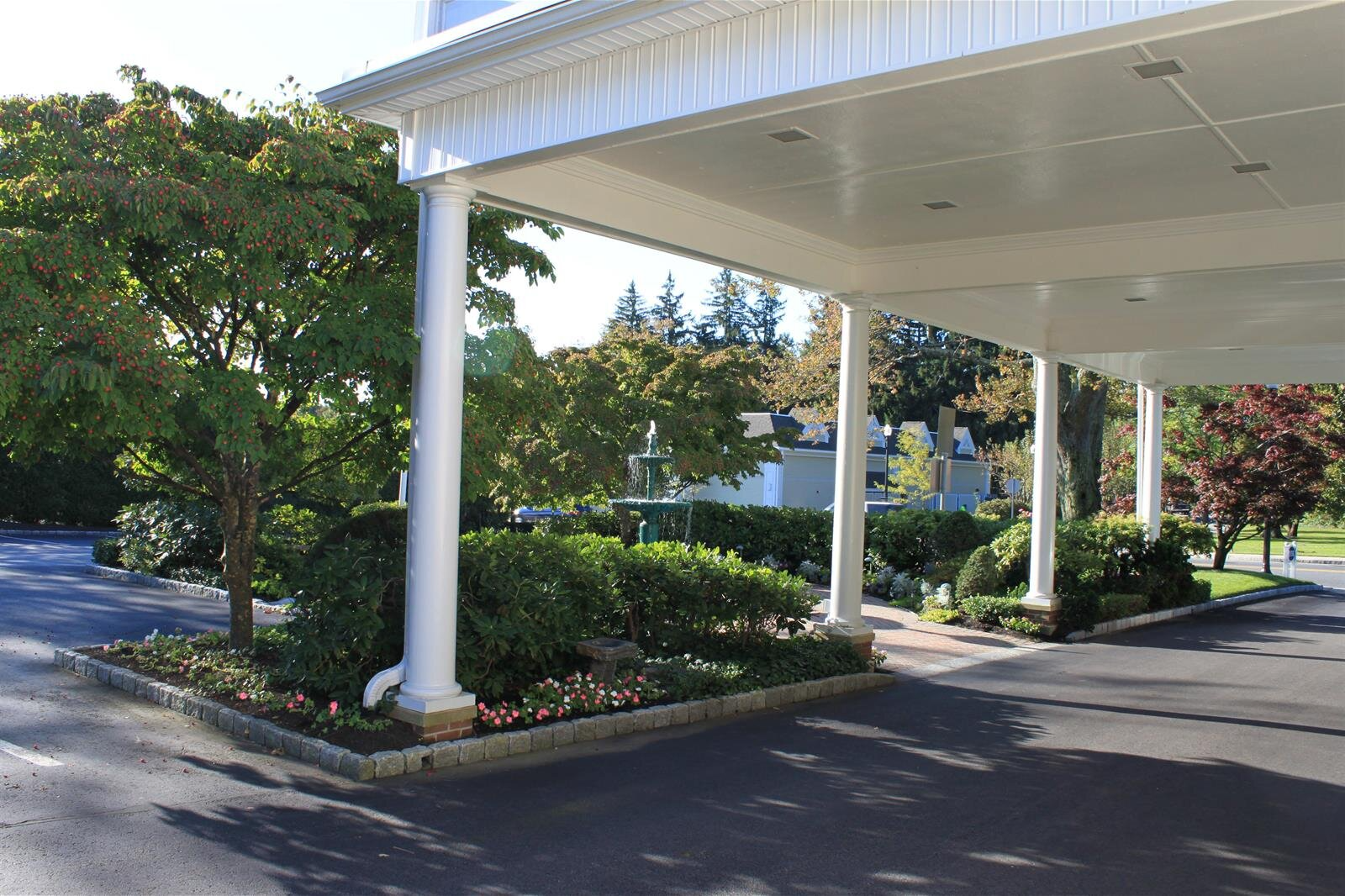 A driveway leading to a building with a canopy over it