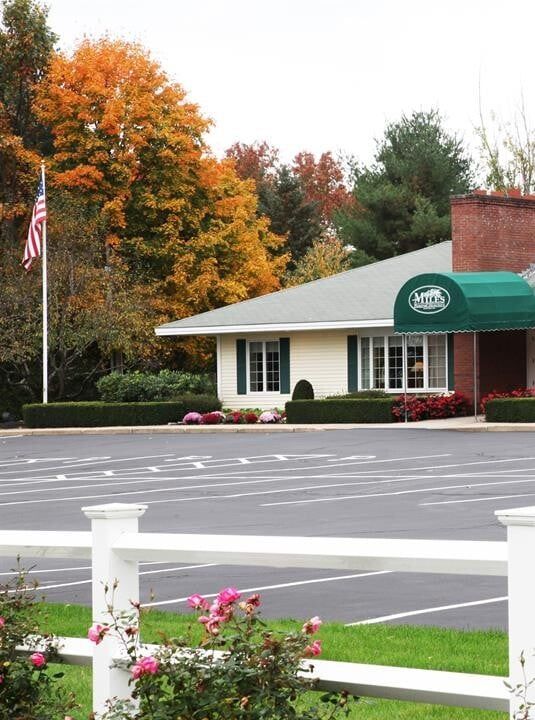 A white house with a green awning and an american flag
