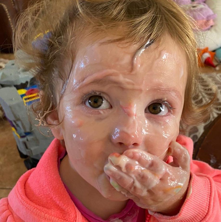 A little girl with a lot of ice cream on her face