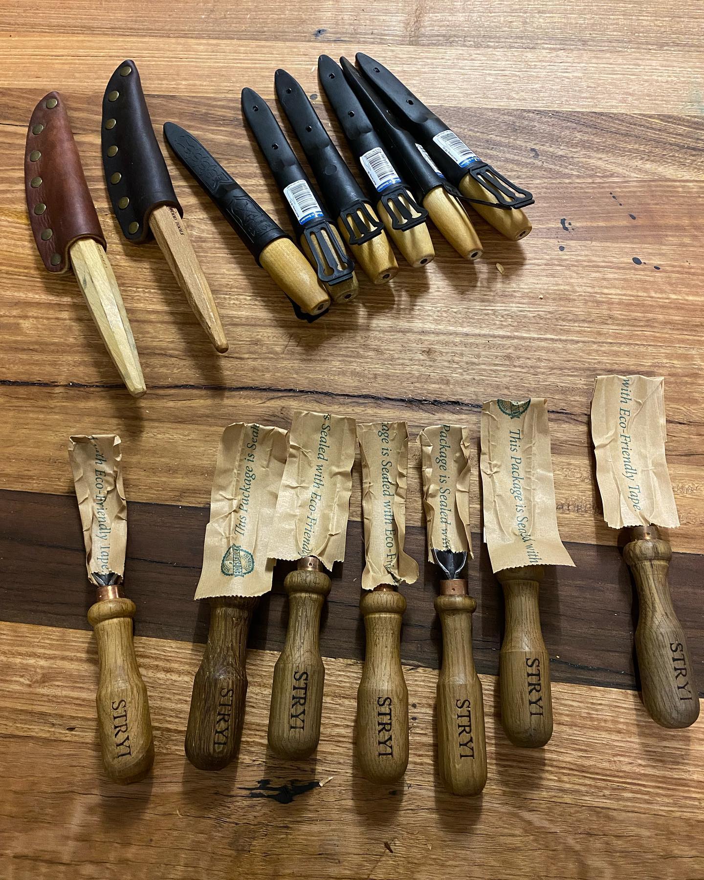 A bunch of knives are sitting on a wooden table