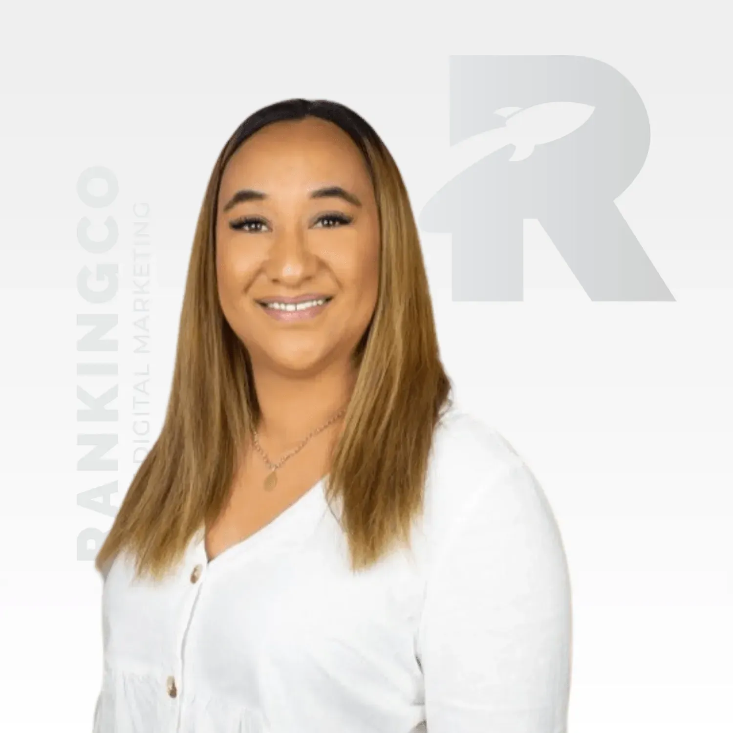 A woman in a white blouse is smiling for the camera