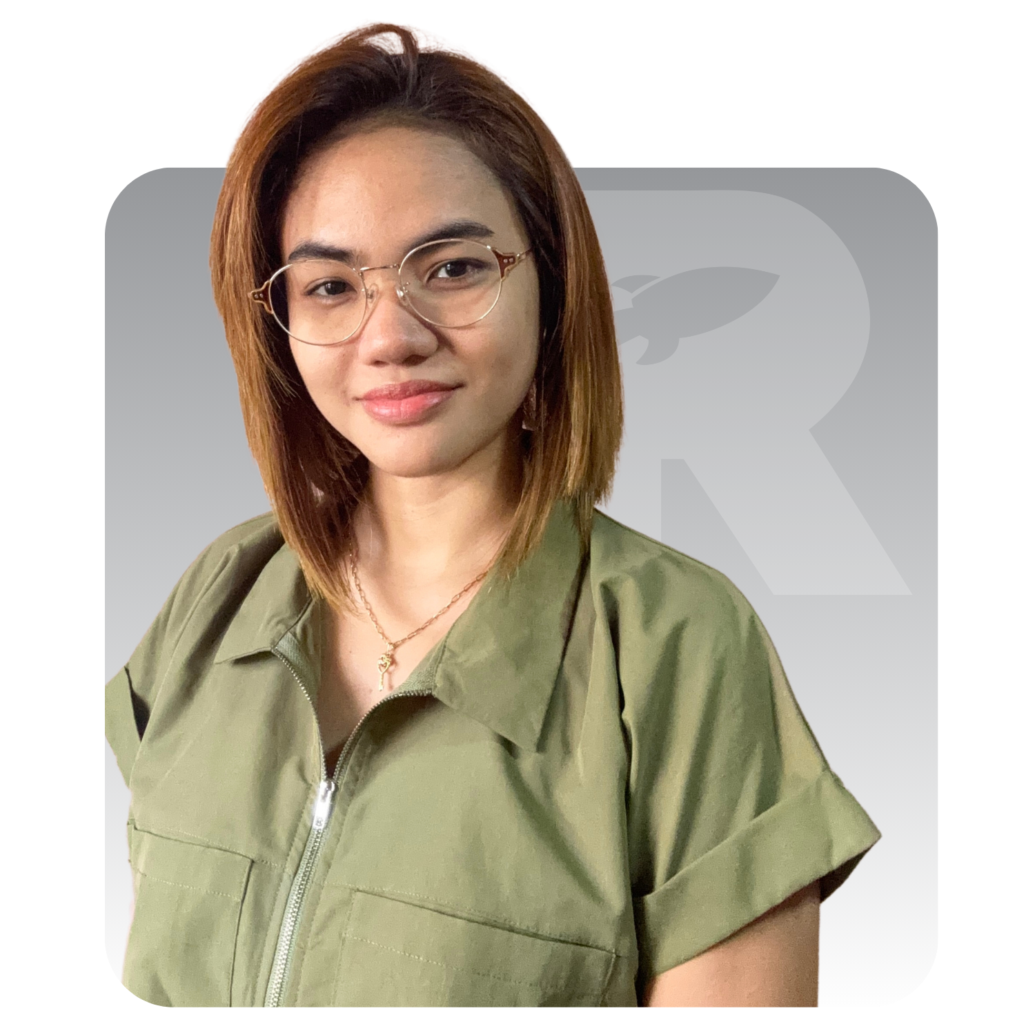 A woman wearing glasses and a green shirt is standing in front of a white background.