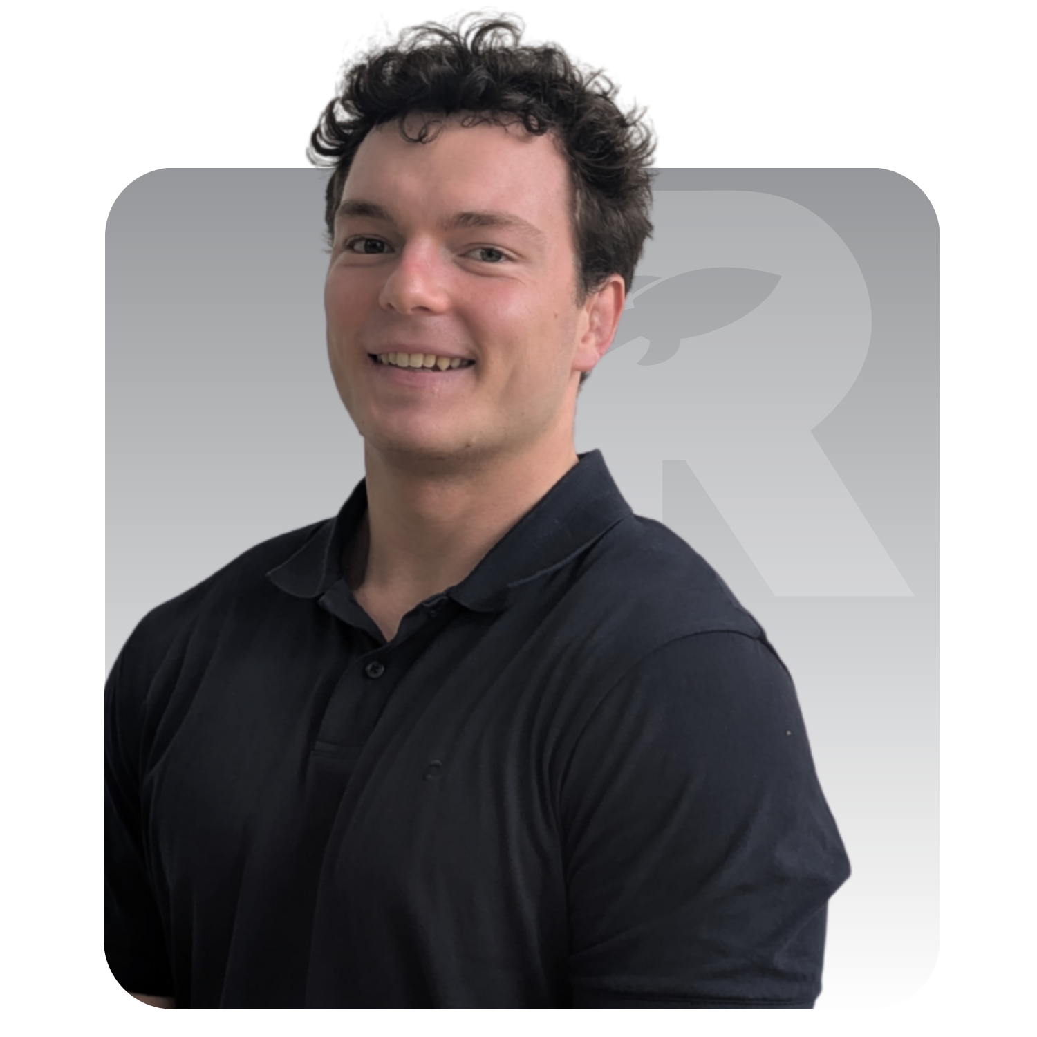 Man with curly dark hair wearing a black polo shirt, smiling, with the RankingCo logo in the background.