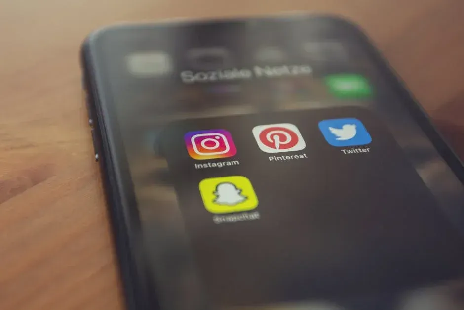 A close up of a cell phone with social media icons on the screen.