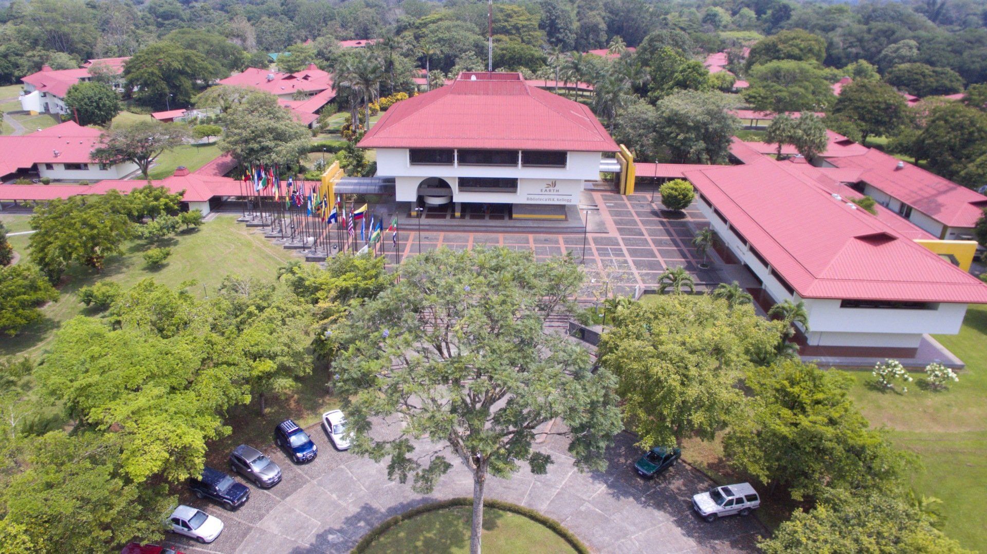 An aerial view of a large building with a red roof